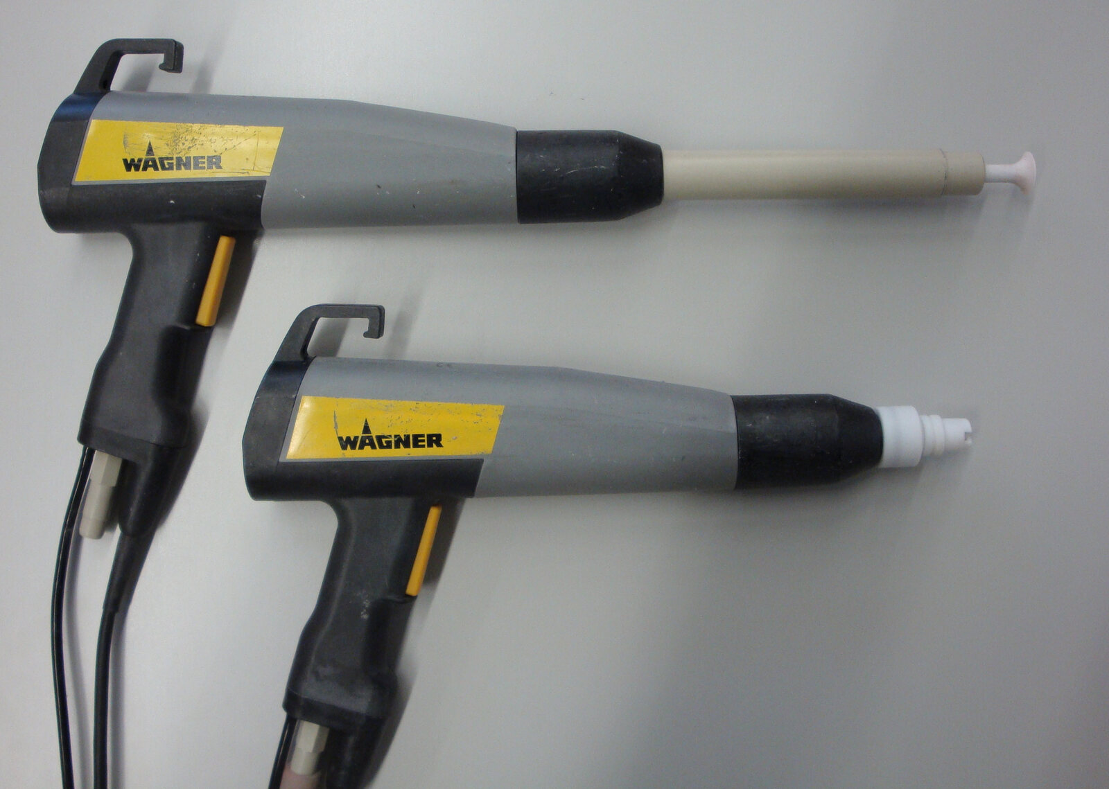 Real Tribo and Corona powder coating guns shown side by side